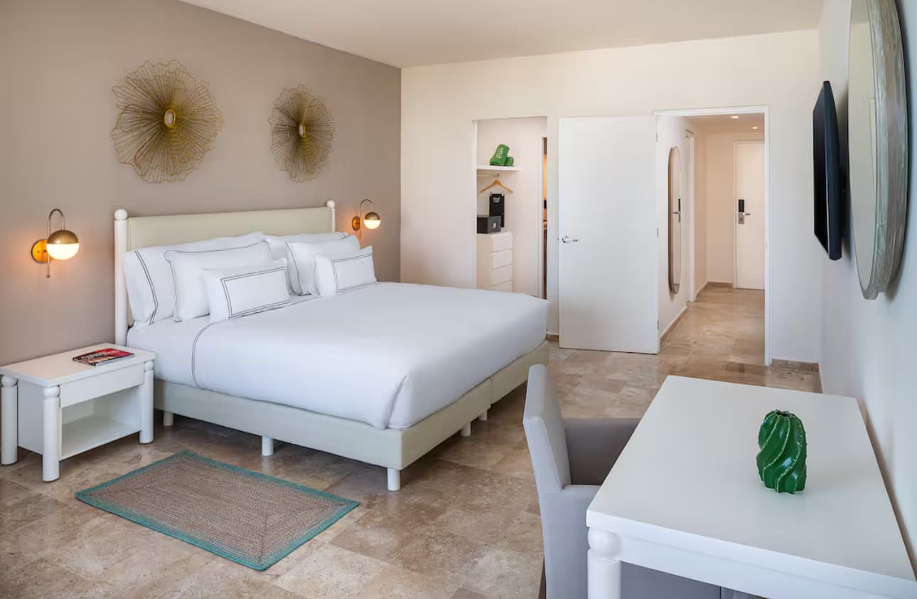 Habitación terminada — cama king con marco retapizado y obra de arte dorada en pared