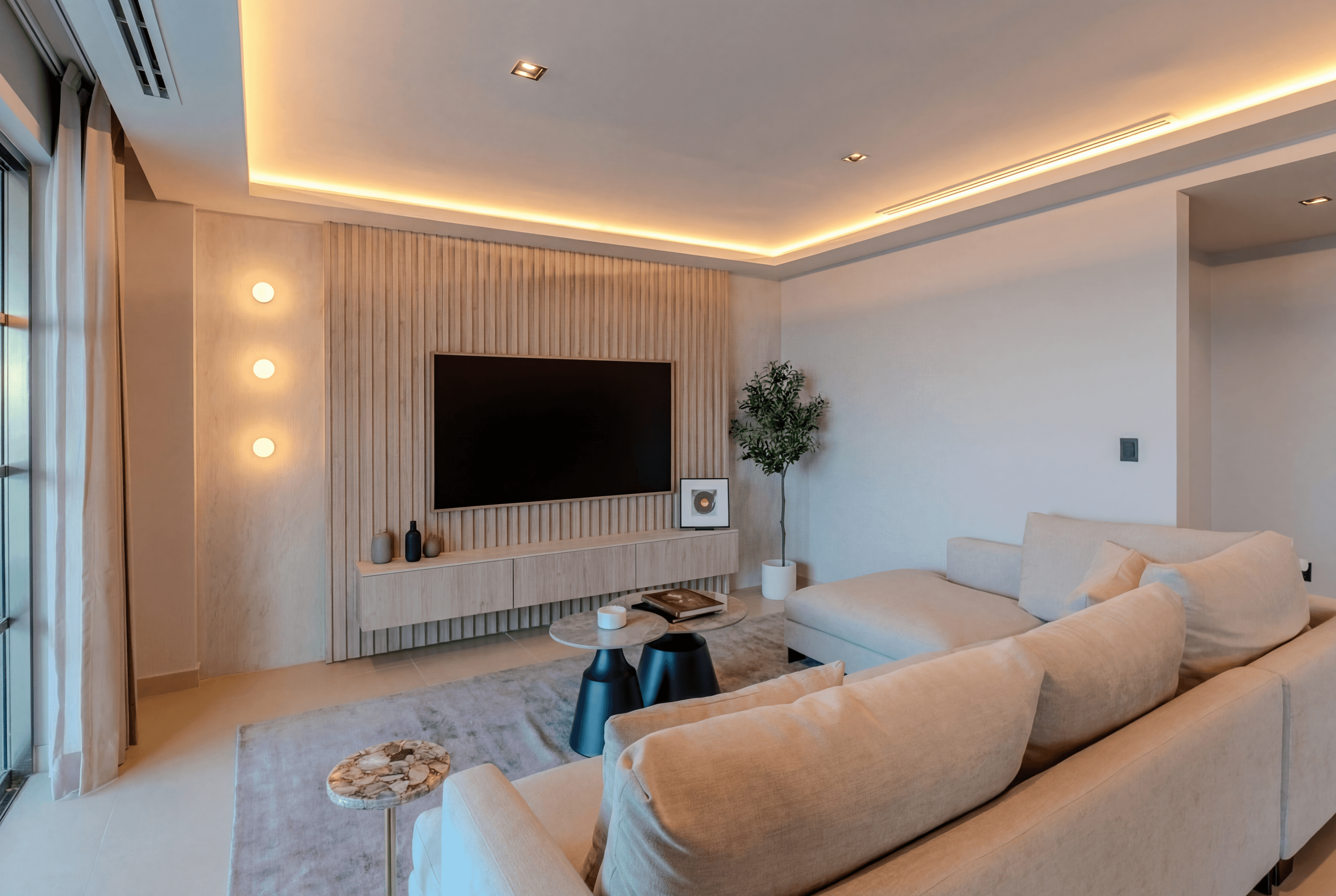 Apus 904 — sala con muro de televisión en lamas de madera e iluminación ambiental cálida