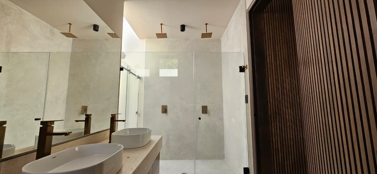 Casa Juuba — regadera doble con herrajes en bronce y detalle de lamas de madera