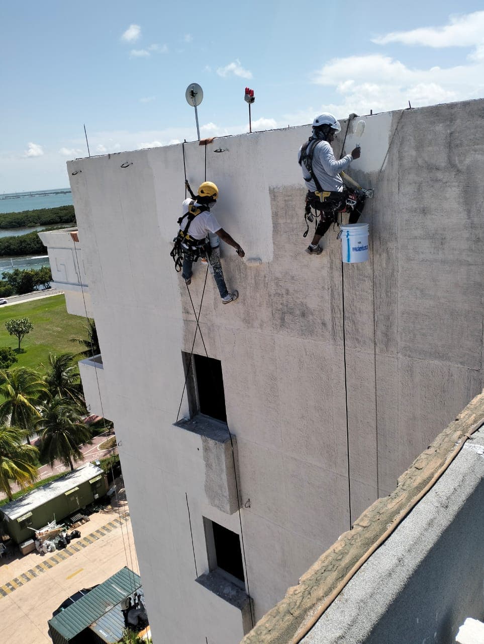 Trabajadores en rapel a nivel de azotea — escala de ejecución en obra, Casa Maya